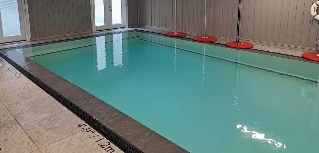 Sunlit indoor warm water facility with vibrant lane floats and peaceful learning atmosphere