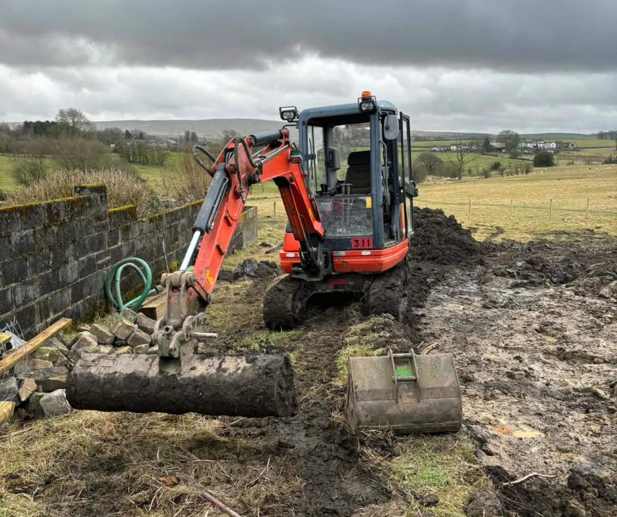 Mini excavator carrying out groundworks and drainage preparation in Lancashire