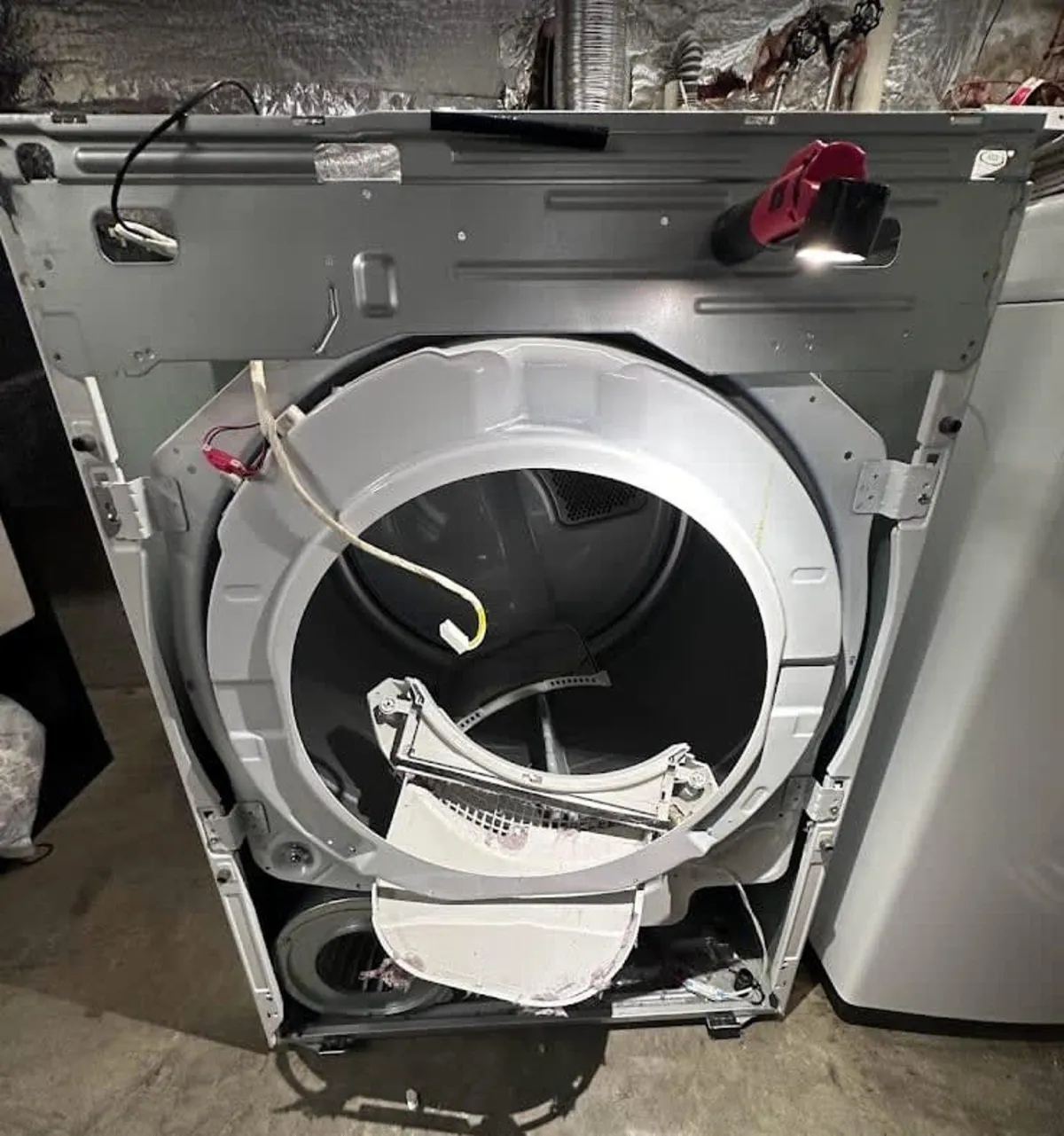 HVAC specialist performing home appliance repair on a clothes dryer in Maryland.