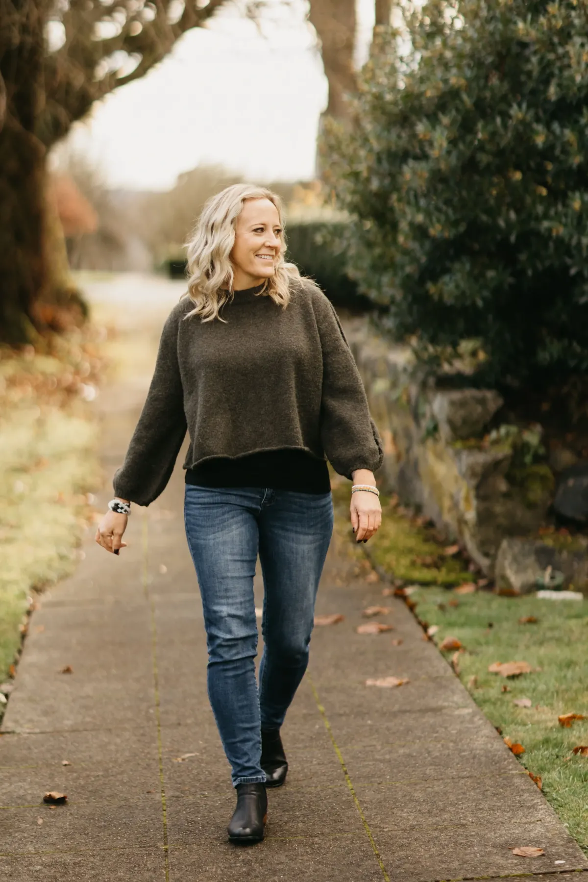 Jessica Alexus smiling softly against a blurred natural background
