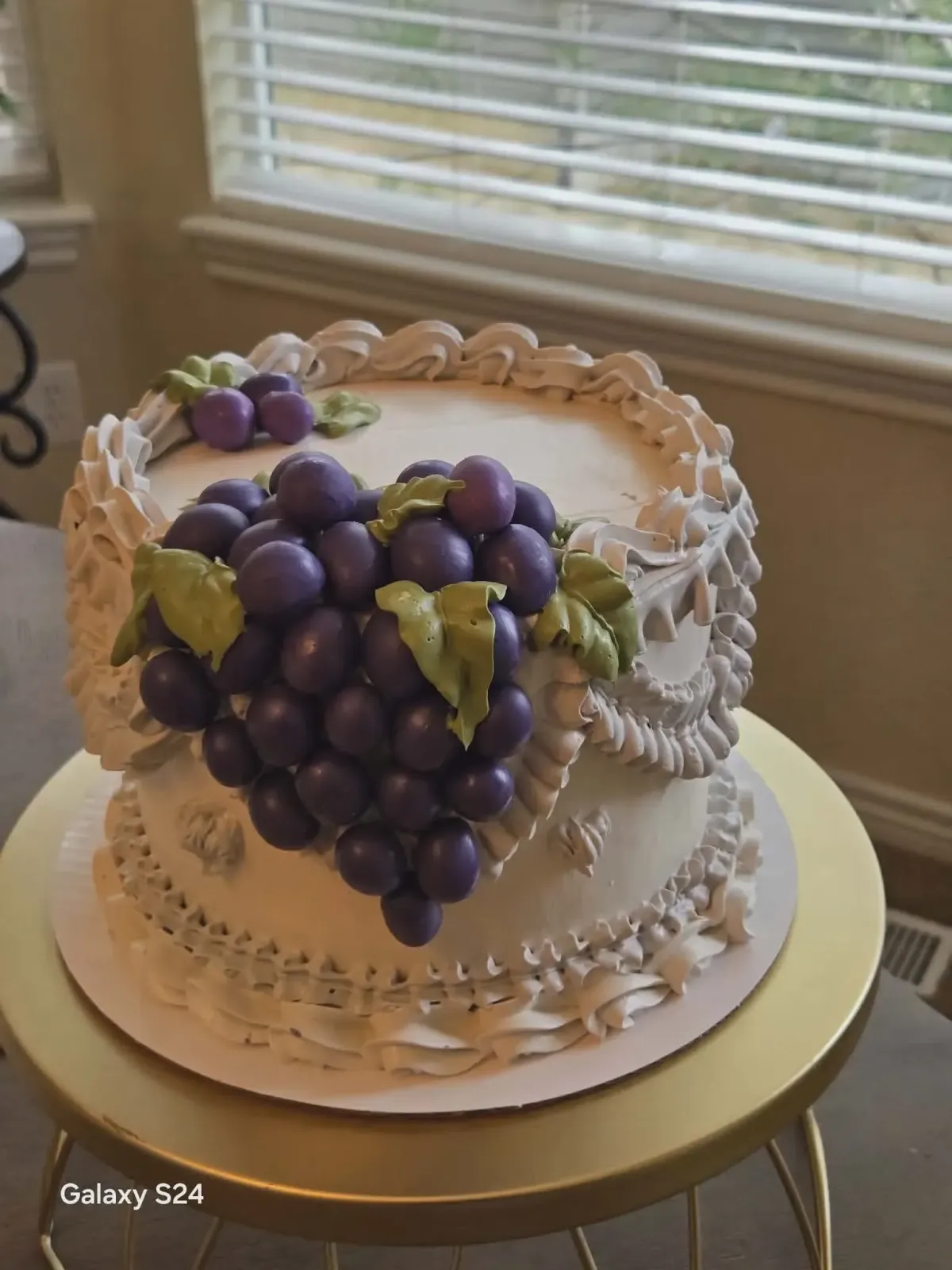 Custom white cake with decorative grape design and piped buttercream frosting, made to order