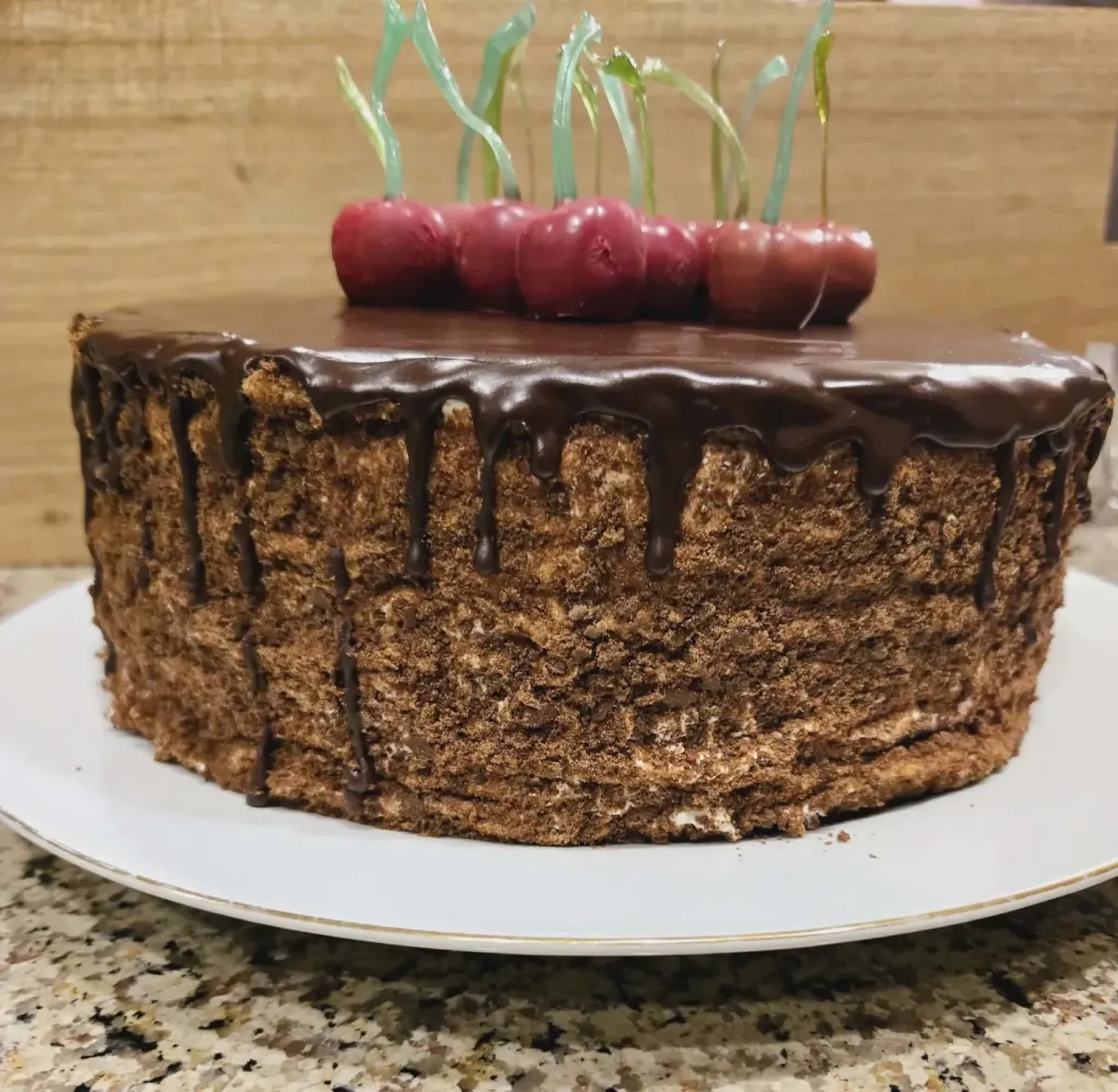 Custom chocolate cake with rich chocolate drip and fresh cherry topping, made to order