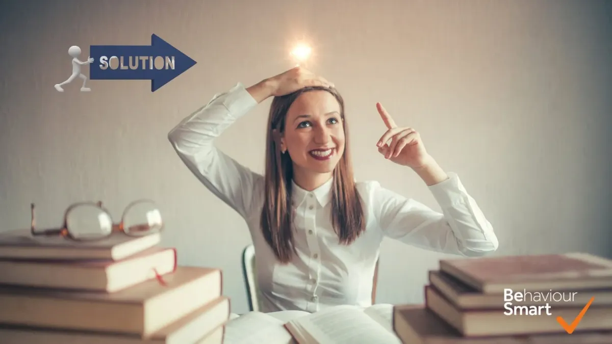 Smiling teacher with a lightbulb above her head pointing to a solution arrow, symbolising behaviour management ideas