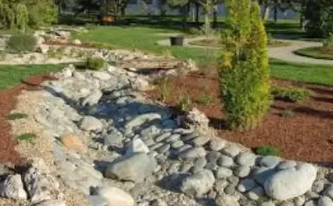 Dry creek bed drainage and rock landscaping by Coastal Virginia Landscape & Design