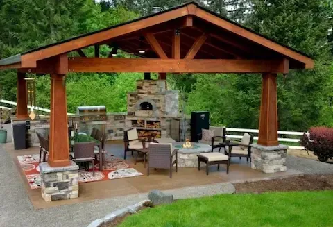 Covered outdoor living pavilion with stone fireplace by Coastal Virginia Landscape & Design