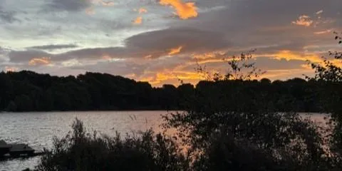 Sunset over the water and woodland beside Core Path 13
