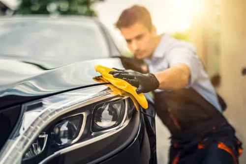 A man using a microfiber towel to finish of an excellent detail, representing our full detail service.