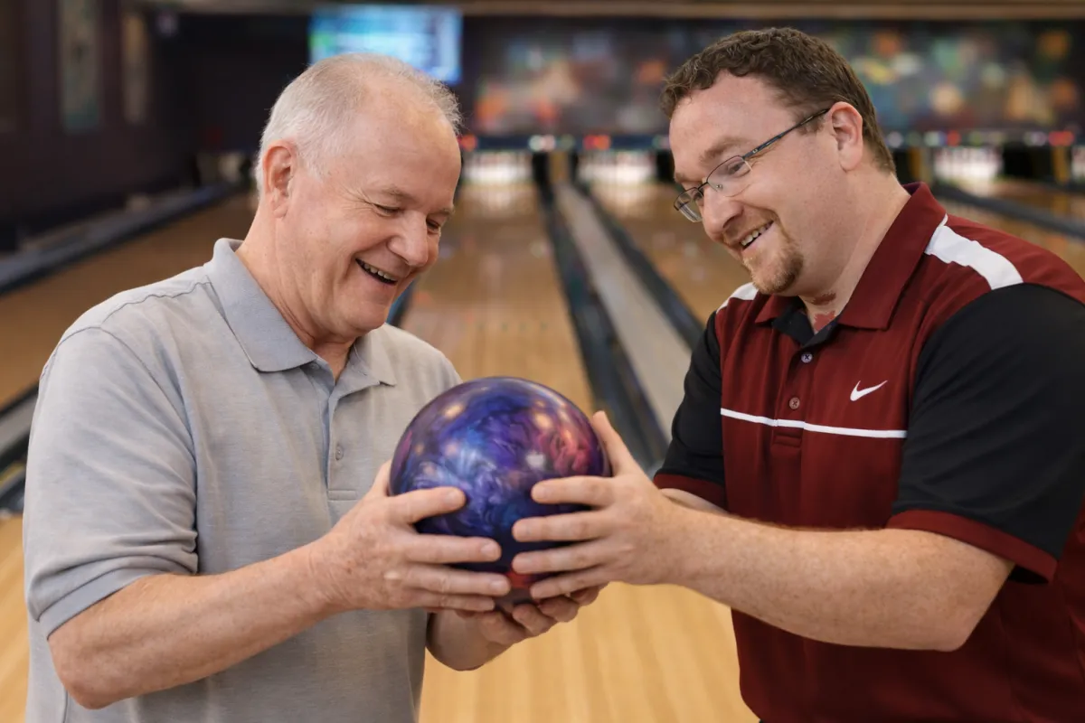 Modern bowling alley lounge with comfortable seating, a calendar open on a tablet, and a friendly staff member ready to assist. Welcoming, bright, and organized environment.
