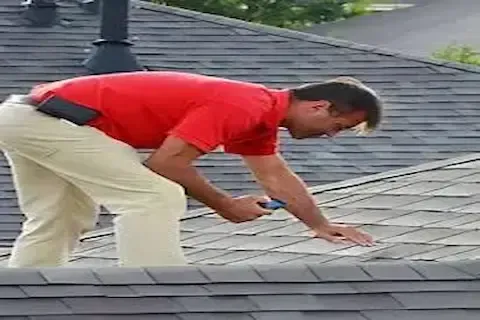 Roof inspector examining asphalt shingles up close during inspection by Coon Rapids Roofing Pros