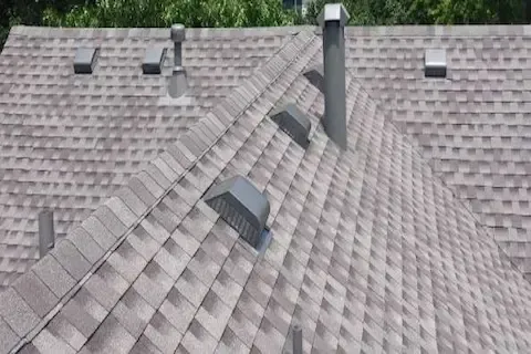 Finished residential shingle roof with multiple vents and chimney by Coon Rapids Roofing Pros