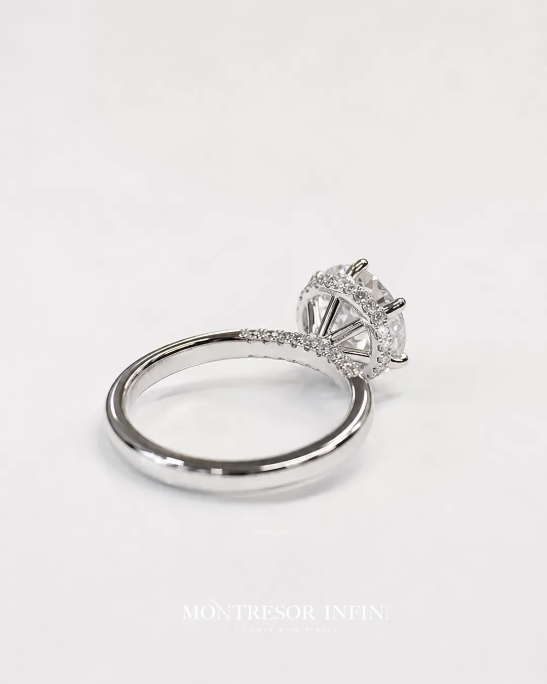 Custom hidden halo diamond engagement ring with pavé band in white gold by Montresor Infini.