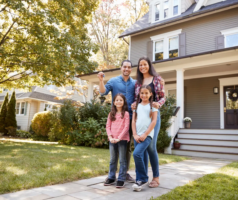 family celebrating homeownership in front of new house