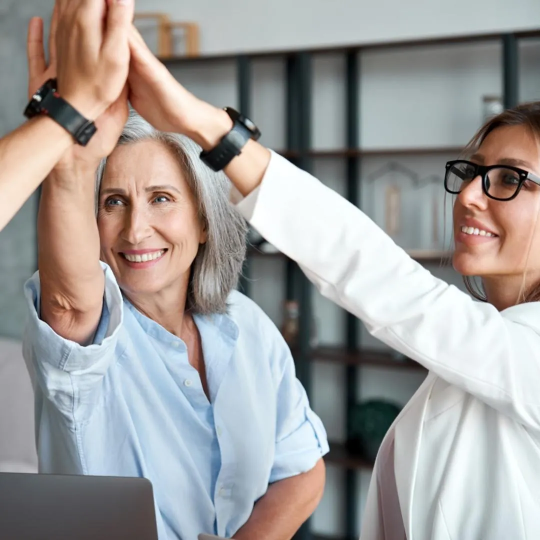 Business women high-fiving eat other