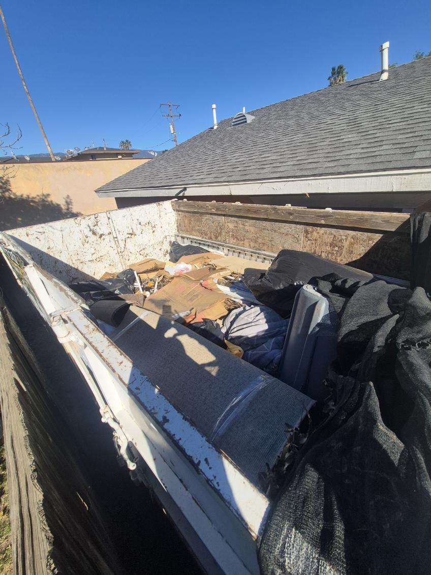 Dumpster filled with household debris and furniture - Blanco's Hauling and Handyman Service in San Bernardino