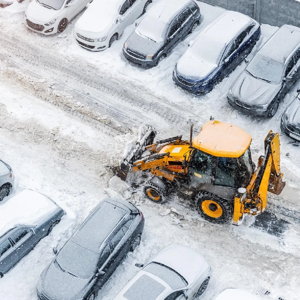 A Snow Removal Vehicle Removing snow from a parking lot.