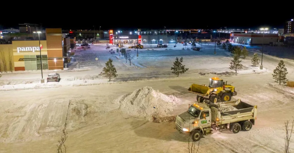 Bird eye view of a parking lot full of snow and a Snow removal truck.