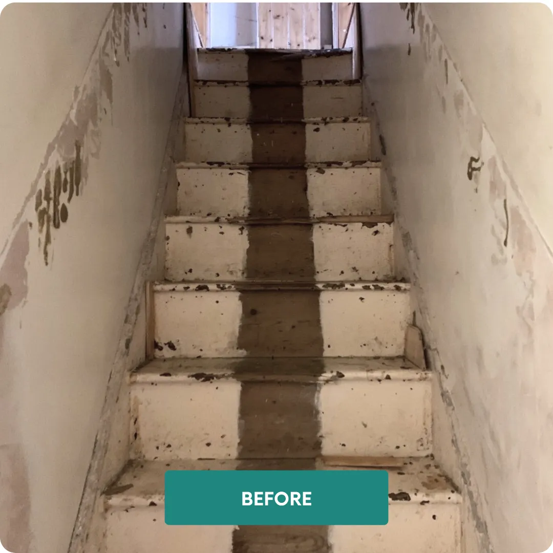 Staircase before renovation showing worn timber treads and damaged stairwell finishes 
