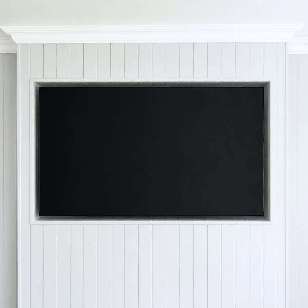Custom tongue and groove wall panelling with built-in television recess and concealed cabling 