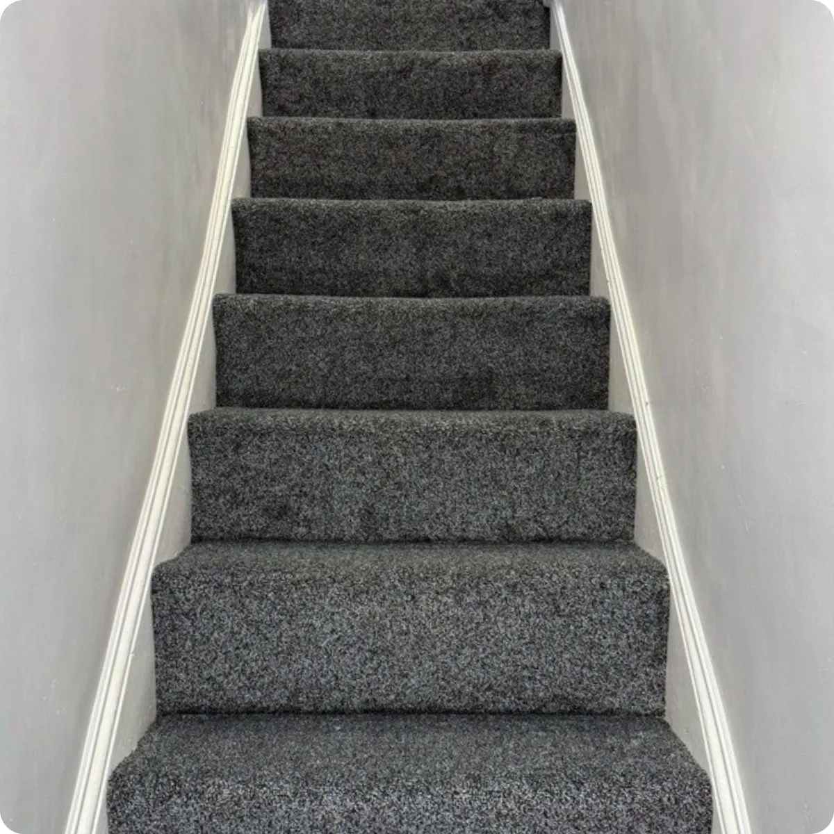 Renovated staircase with fitted grey carpet, refreshed woodwork and redecorated walls 
