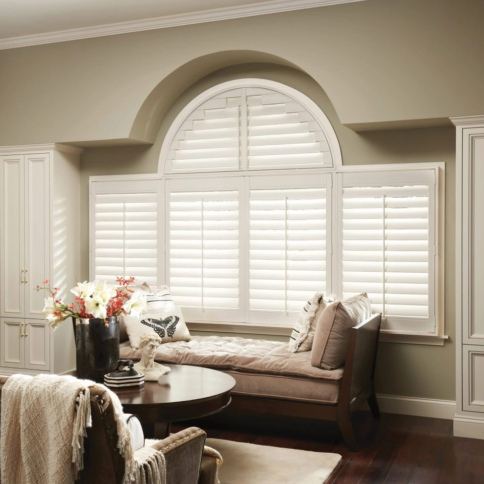 a closed garage door with a red trash can in front of it