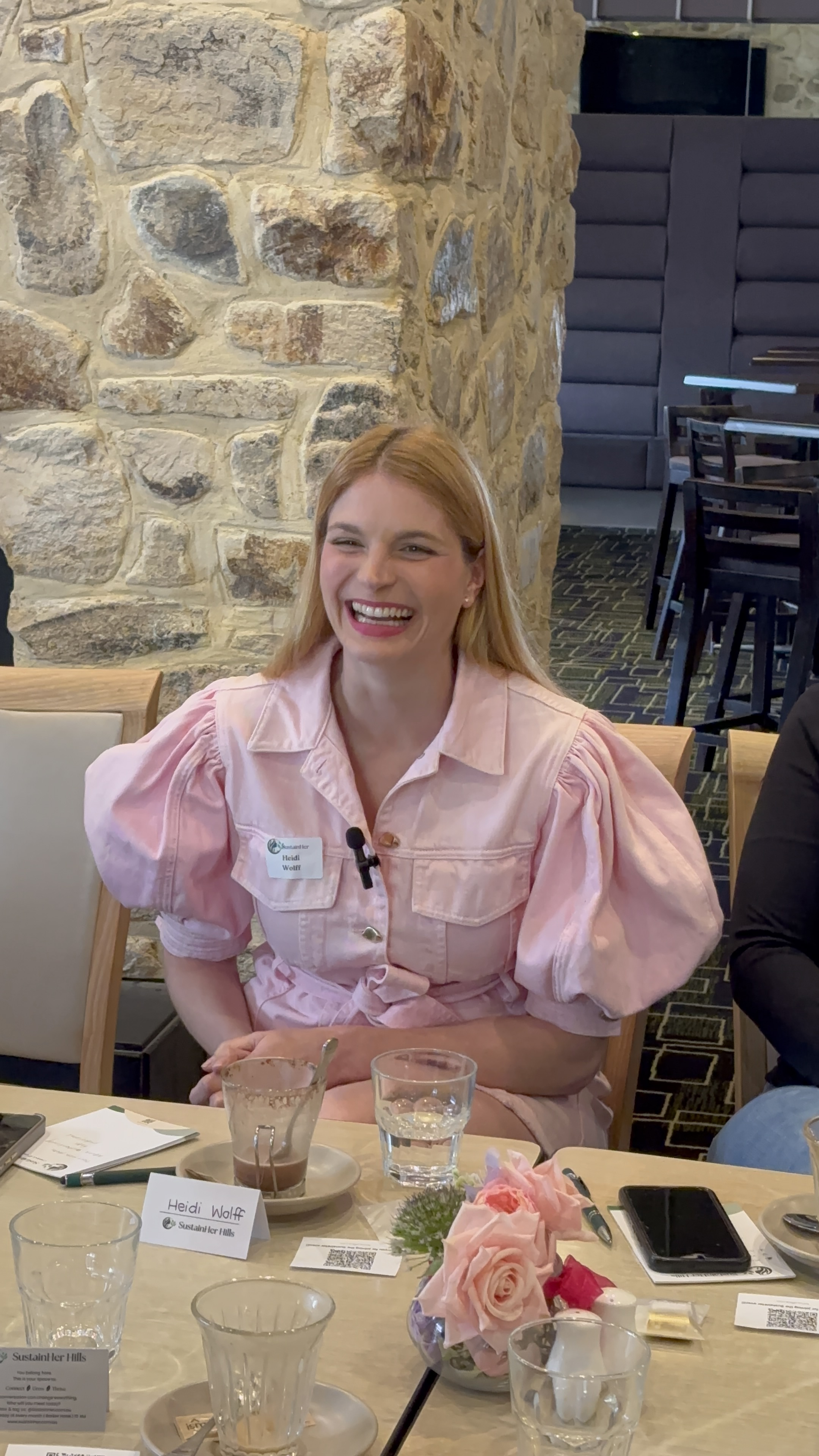 A confident female keynote speaker addressing an attentive audience in a bright conference room, with a large presentation screen behind her. The audience is diverse and engaged, and the atmosphere is energetic and inspiring.