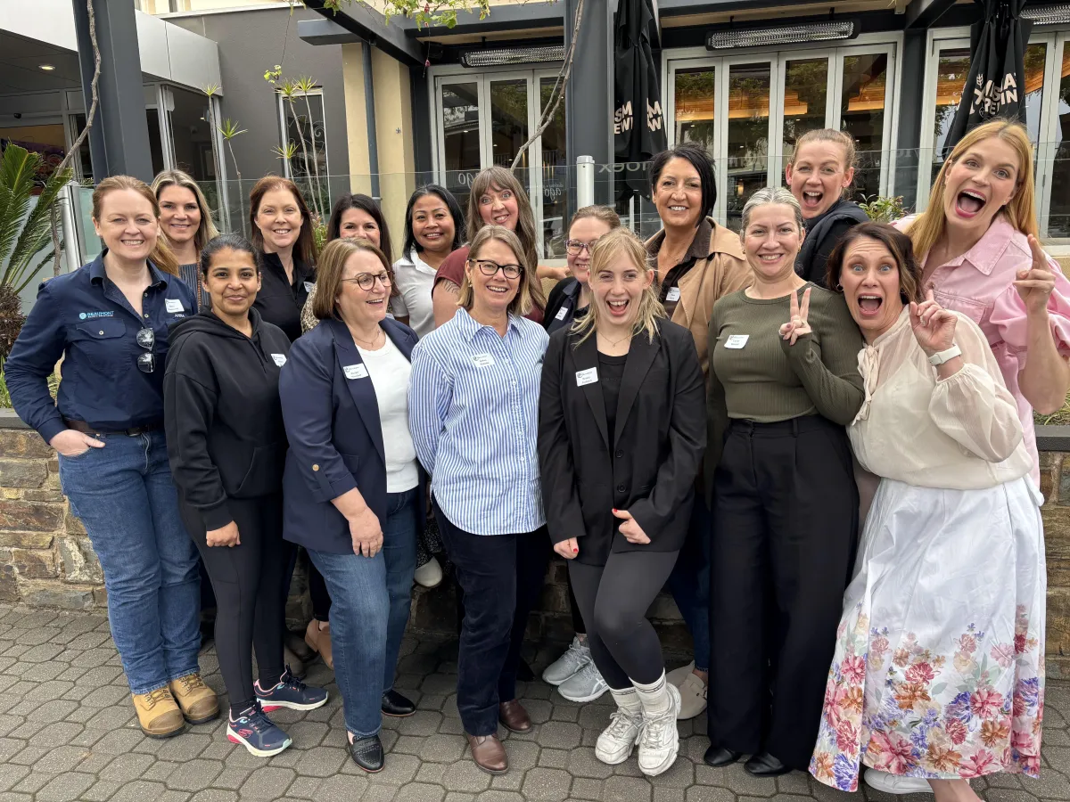 A diverse group of women small business owners in lively discussion at a modern event space, exchanging ideas and business cards, with natural light and vibrant decor, captured in a candid, documentary style. Everyone is engaged and smiling, representing empowerment and collaboration.