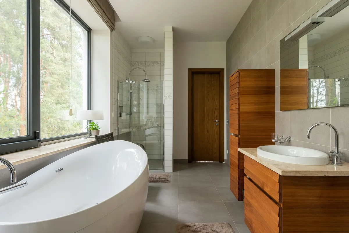 Modern beige bathroom with wooden accents, bathtub and shower