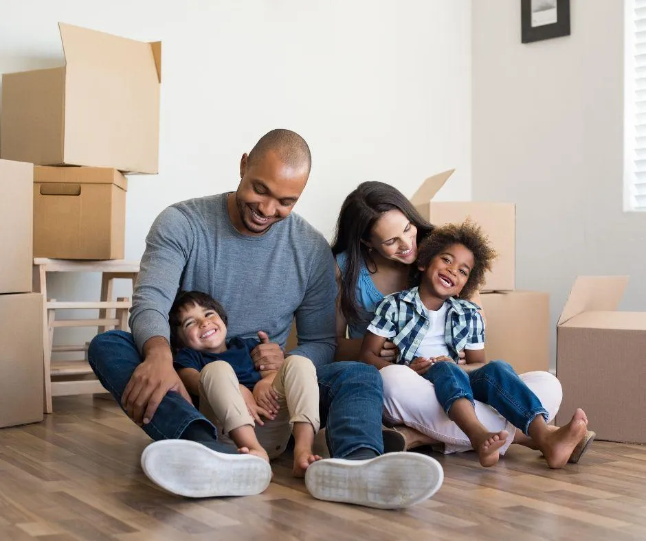 A happy and stress free family smiling whilst sittling on the floor in their home.Removals in Eastboune