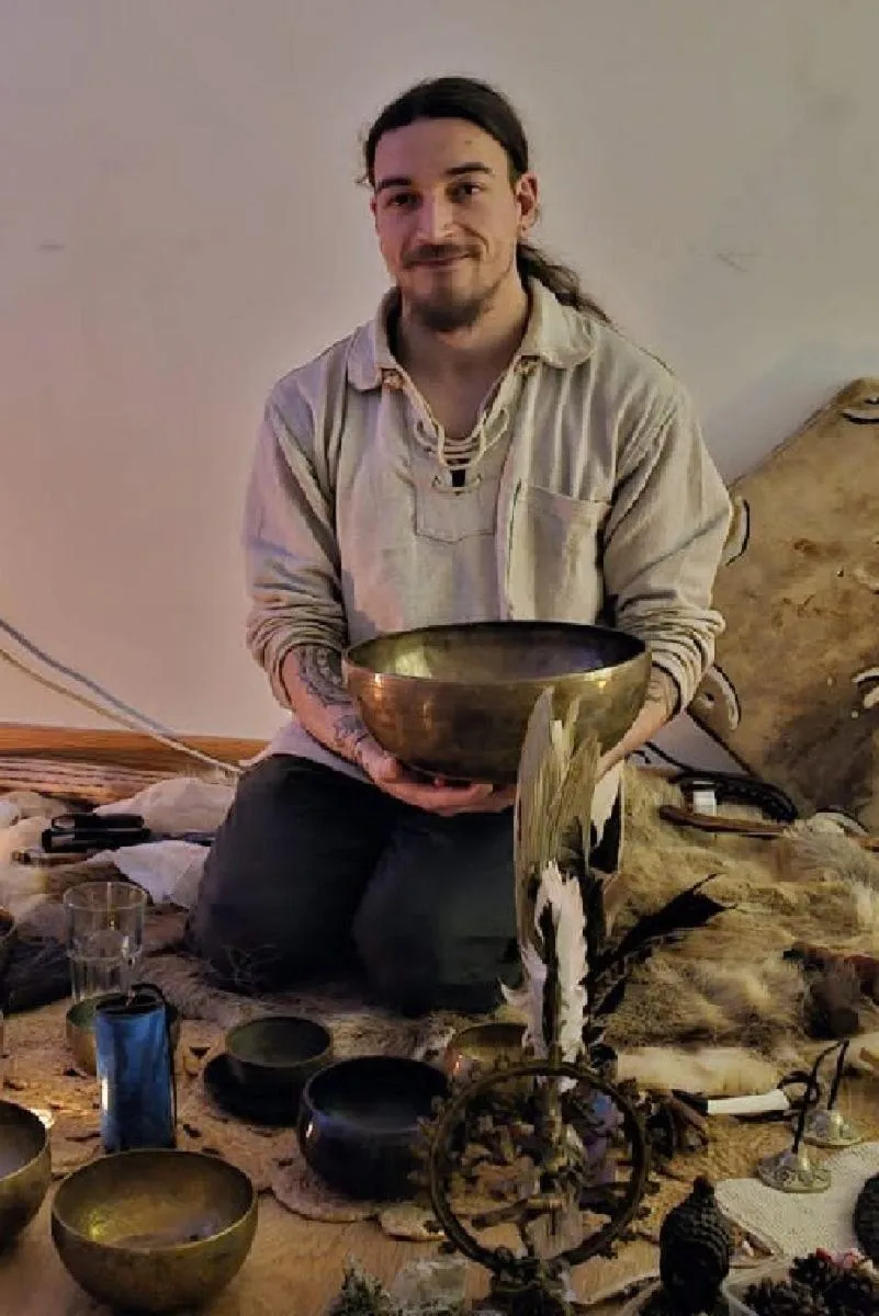 Image of Rory Condor, Founder of Sunyata Sound Healing, kneeling on the floor holding a sound bowl