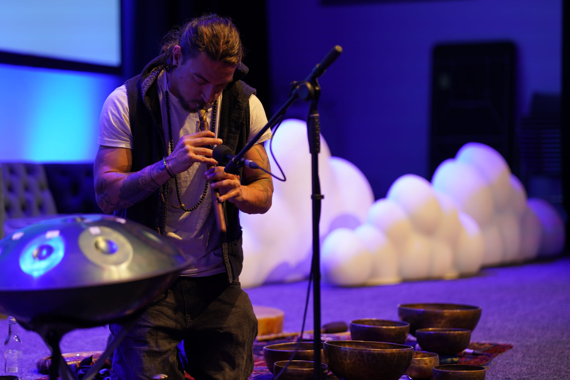 Image of Rory Condor, Founder of Sunyata Sound Healing, kneeling on the floor holding a sound bowl