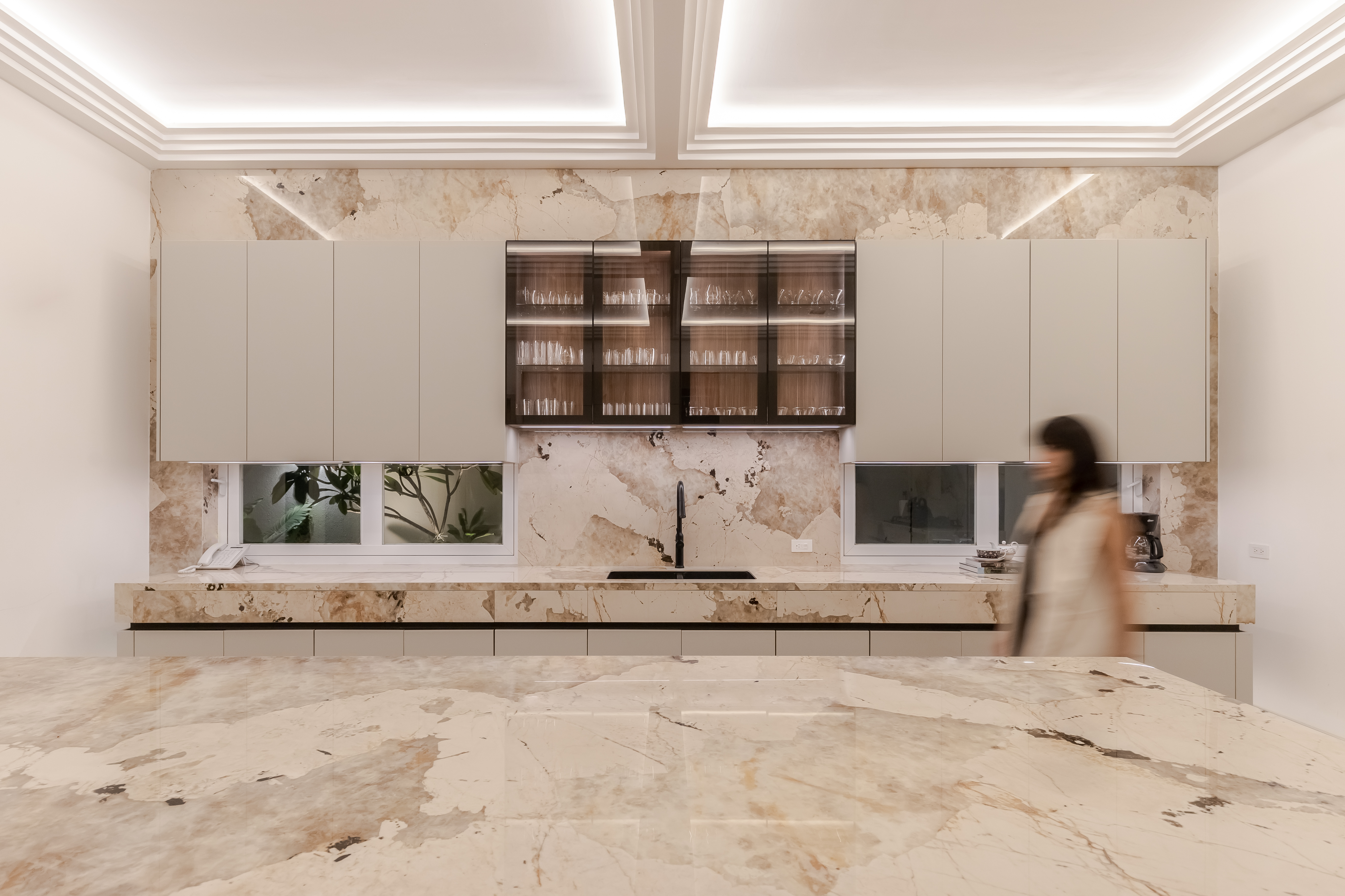 A woman in a patterned jacket looking at a fence