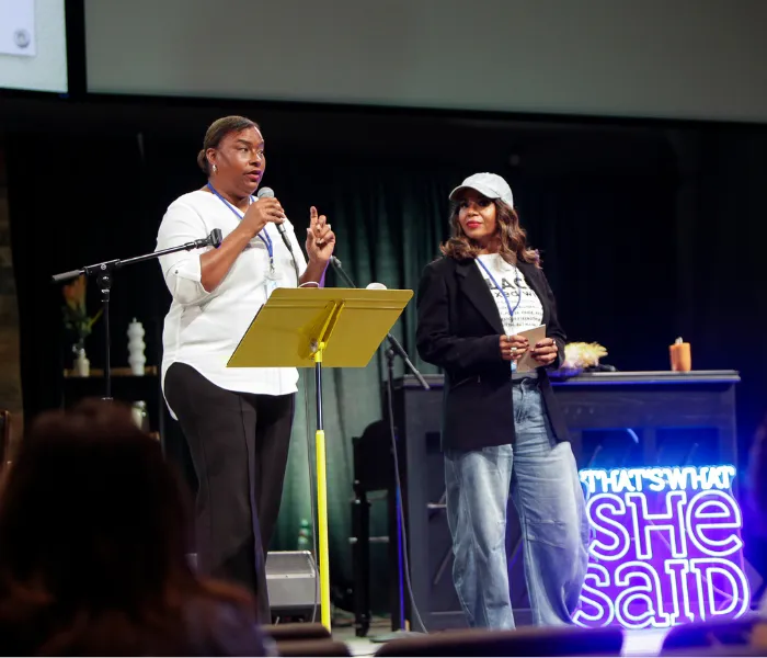 Two women on stage presenting a workshop session