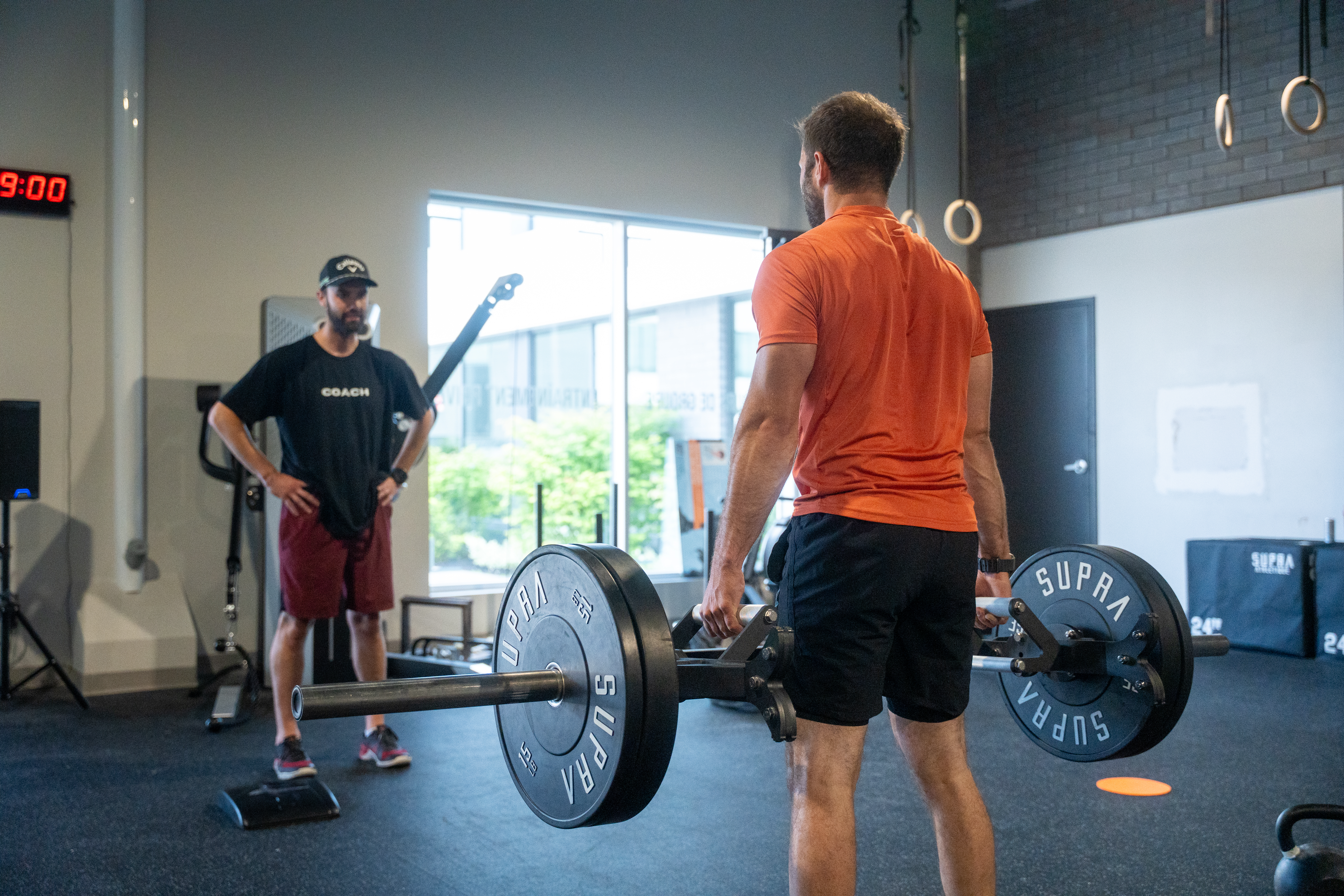 Adulte occupé s’entraînant dans un gym fonctionnel, symbolisant une transformation durable malgré un horaire chargé.
