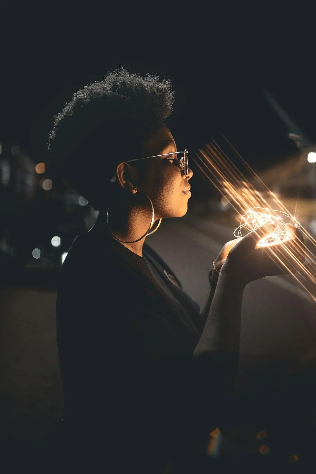 confident black woman with natural hair holding light in her hands