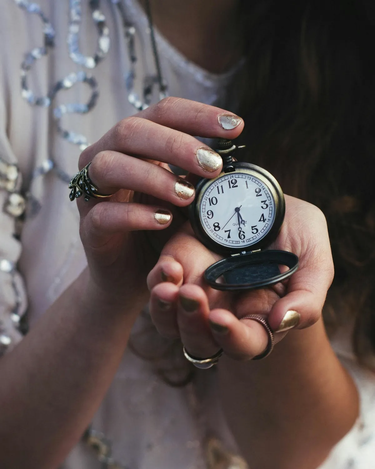 Woman holding pocket watch, time is precious