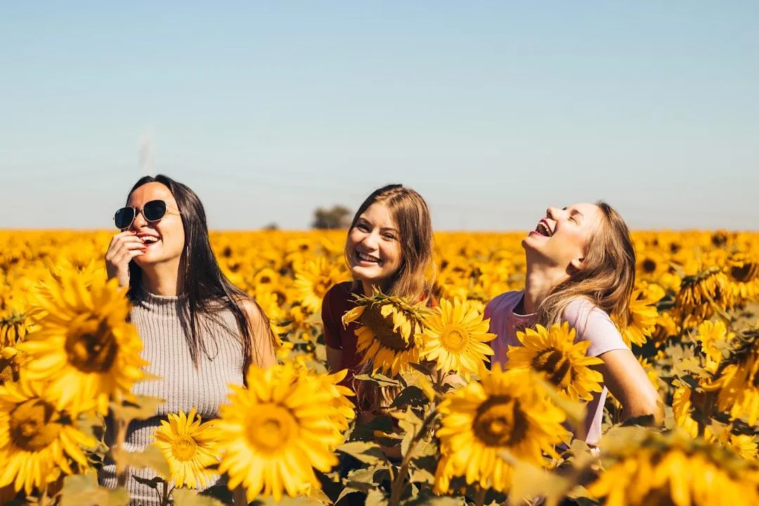 3 women in sunflower field fake laughing hiding true self