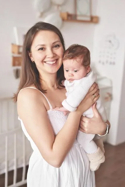 Happy young mother holding her precious baby