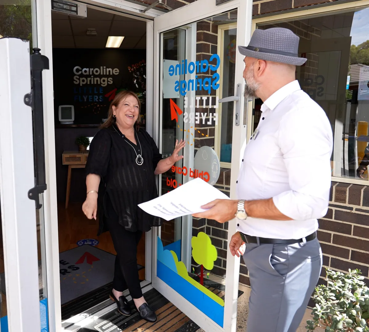 childcare centre at Caroline Springs Little Flyers, featuring an early learning director welcoming a visitor at the entrance for authentic centre marketing content