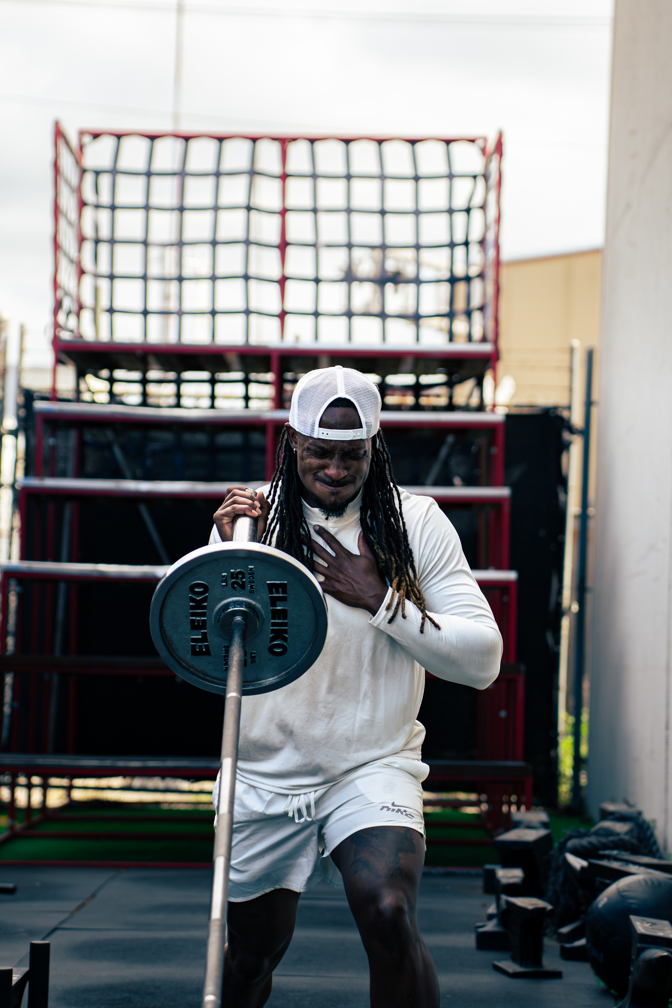 Athlete executing heavy resistance strength training in a high-contrast dark facility