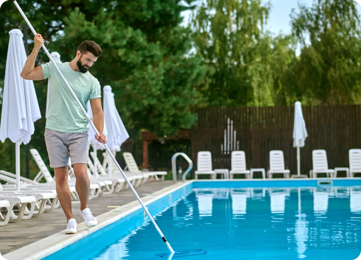 "Pool technician expertly cleaning a residential pool, ensuring crystal-clear water and a well-maintained swimming area."