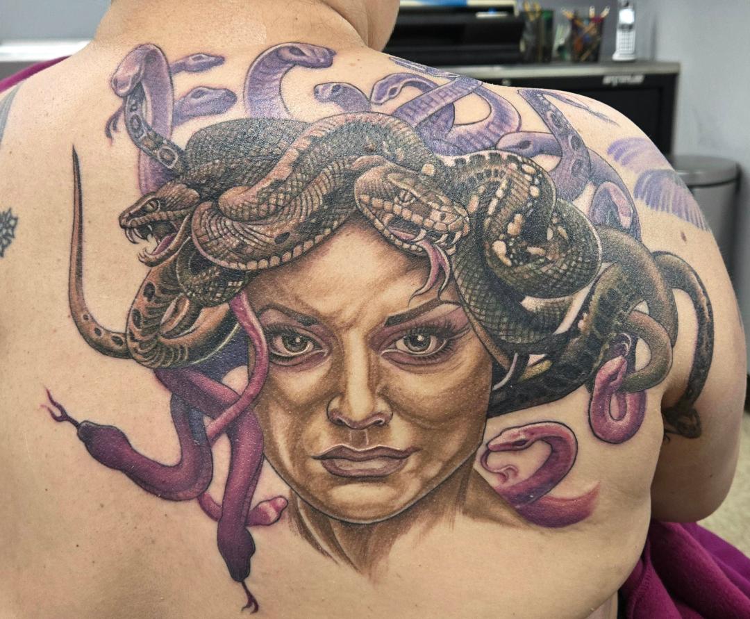 a man getting a tattoo on another man's arm