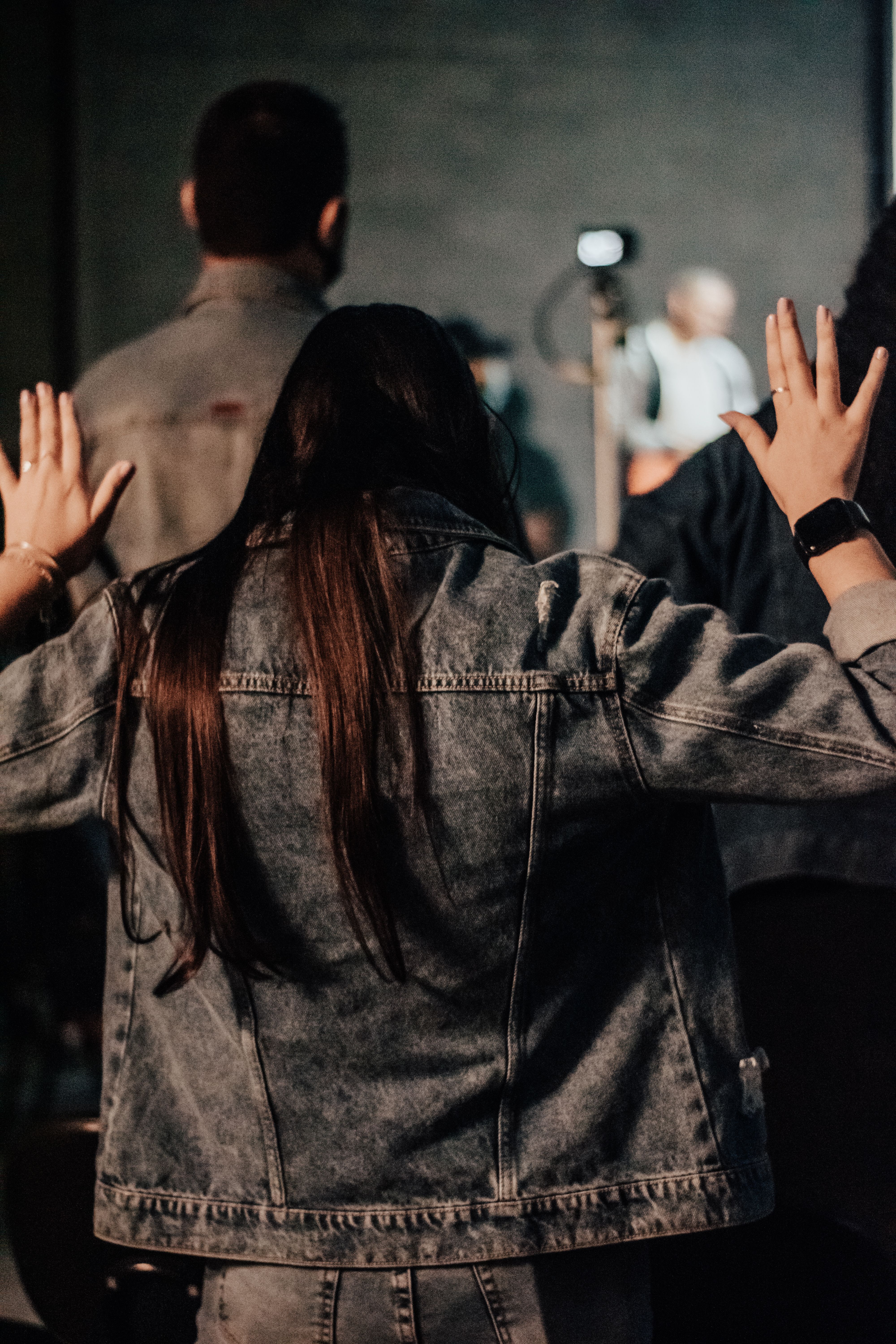 Christian worshipper raising hands in praise during a church service, expressing wholehearted devotion, faith, and love for God's presence.