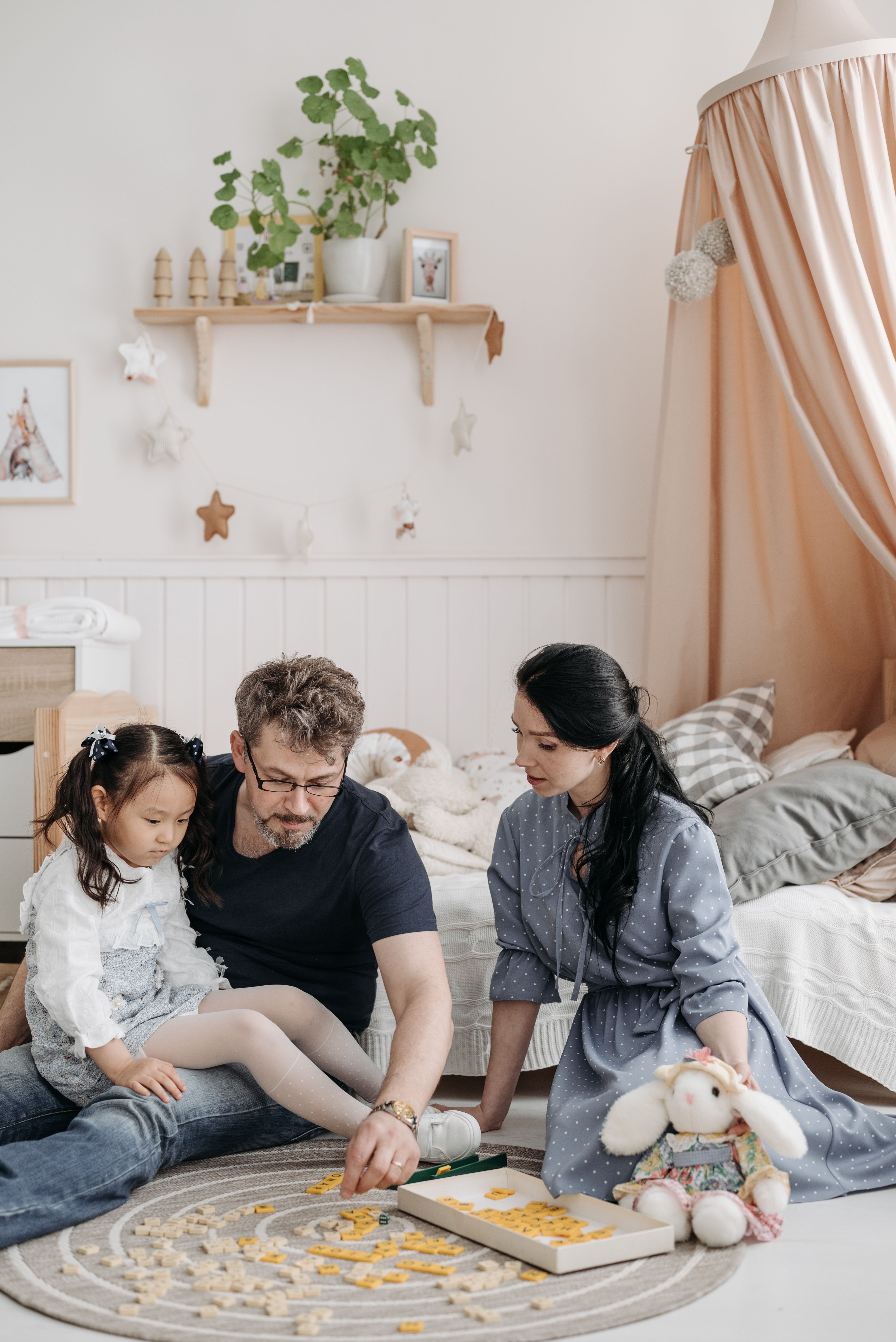 Parents spending quality time with their young daughter at home, playing together and creating a warm family environment where children feel loved, valued, connected, and a strong sense of belonging.