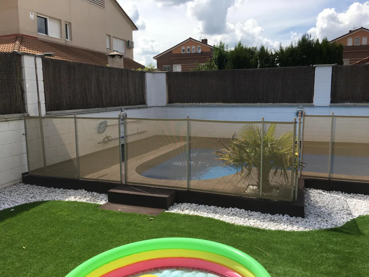 Piscina pequeña rodeada por vallas de seguridad Babysecur en un jardín residencial, ofreciendo protección infantil en un entorno acogedor.