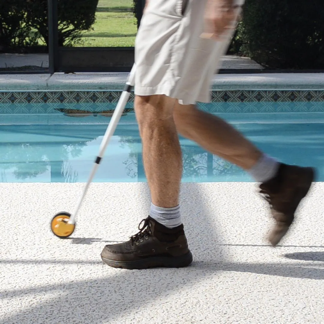 Instalador utilizando una herramienta con rueda para marcar puntos precisos en el suelo junto a una piscina durante la instalación de vallas Babysecur.