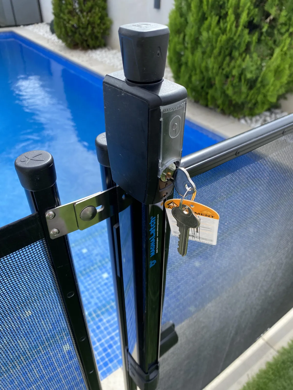 Cerradura de seguridad con llave instalada en una valla para piscinas, diseñada para evitar accesos no autorizados y garantizar la protección infantil.