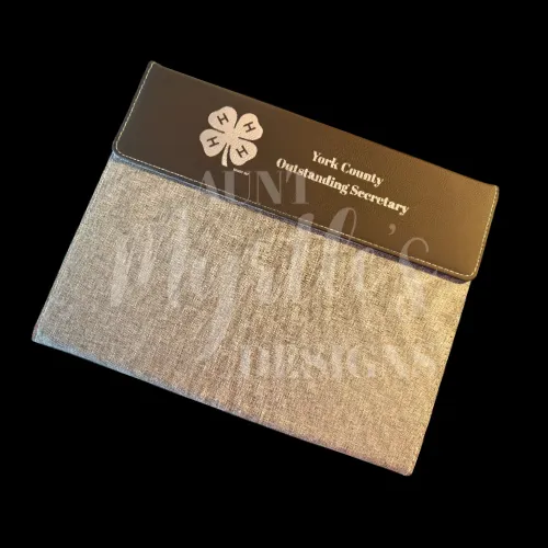 Gray canvas padfolio with black leatherette flap closure with "York County Outstanding Secretary" laser engraved on it with the 4-H clover
