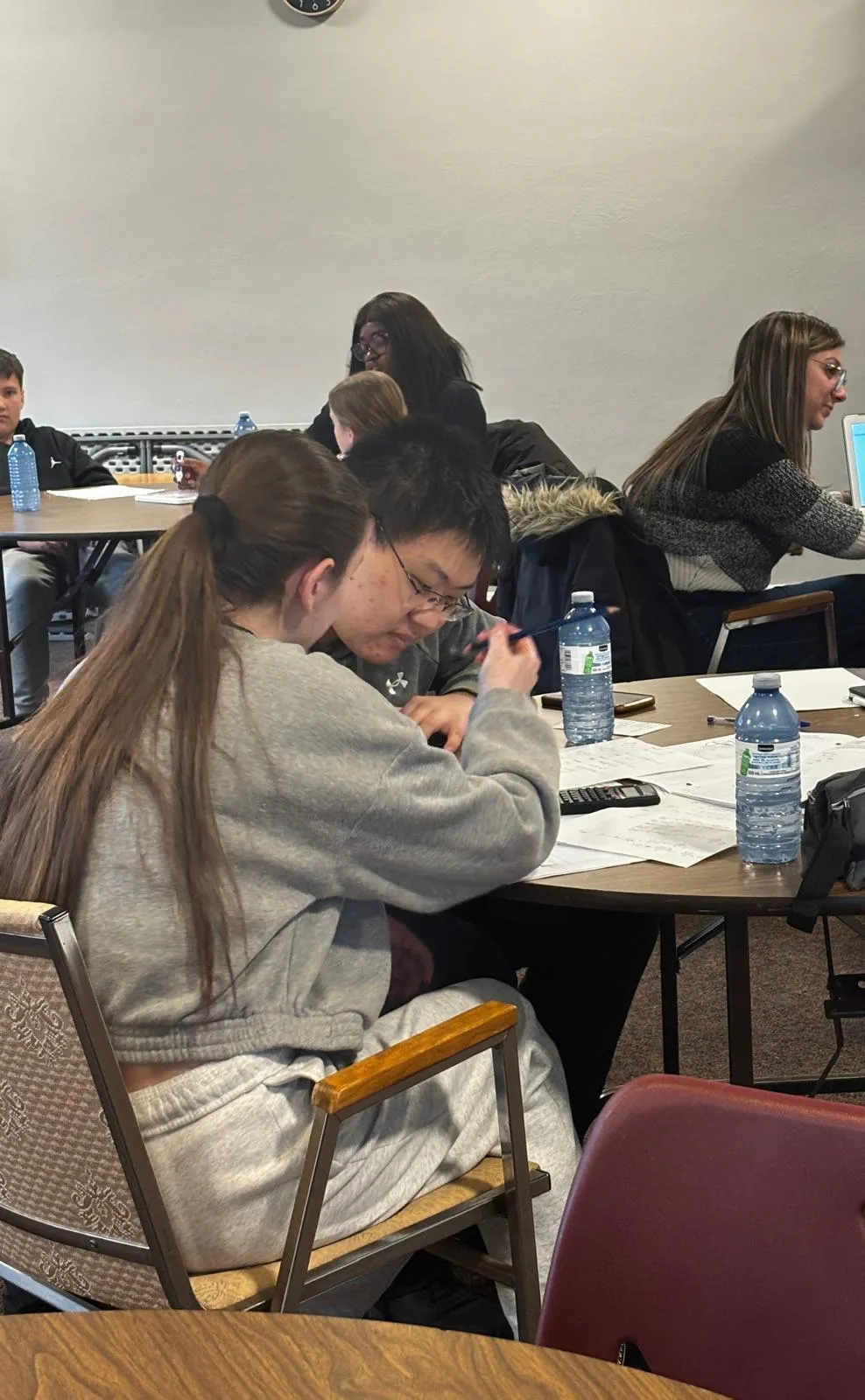 People raising hands towards a man holding a skateboard