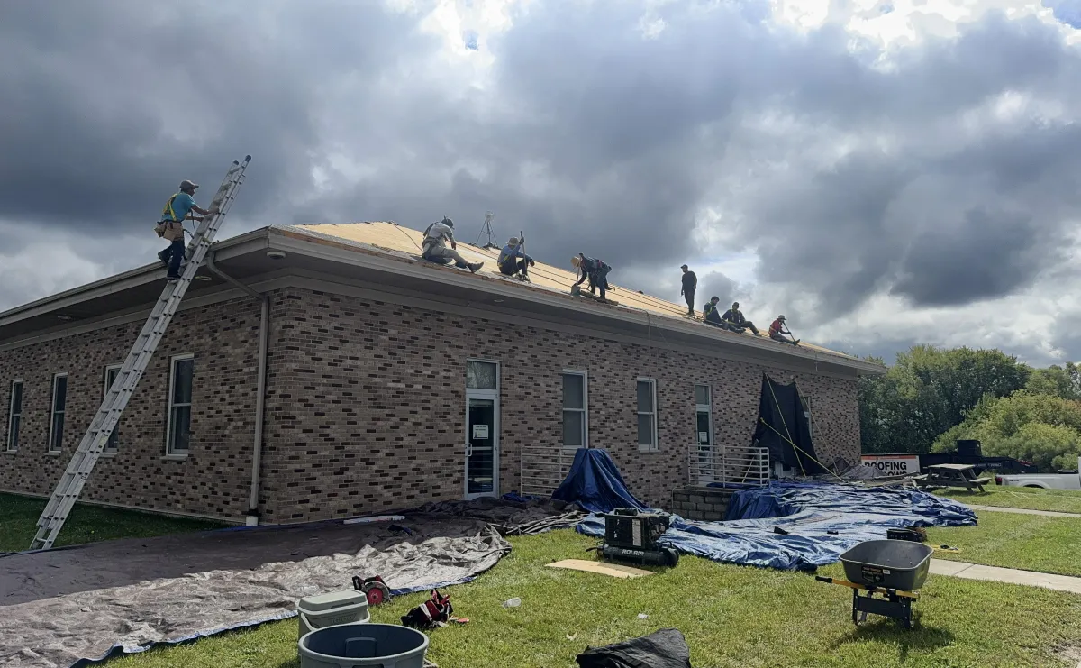 a row of rooftops with a clock tower in the background