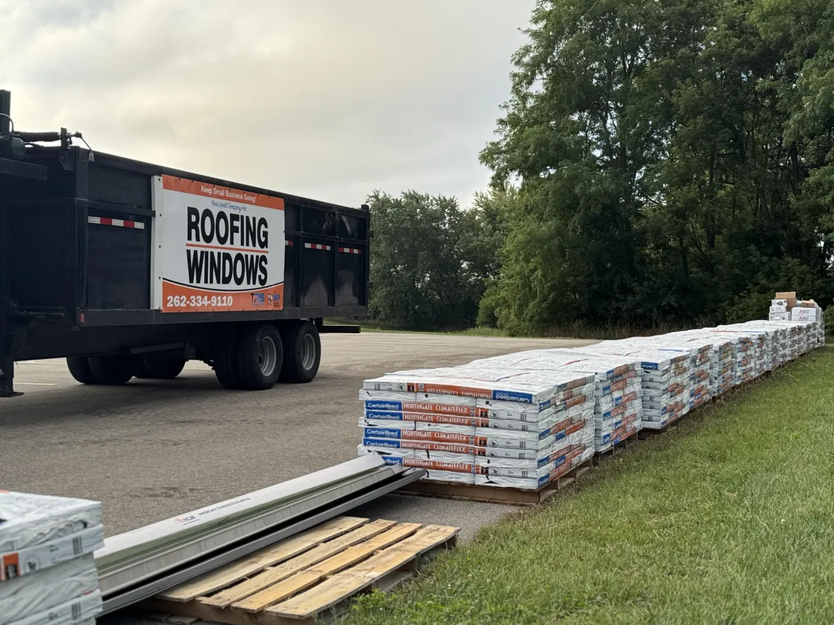 A bird sitting on top of a roof next to a building